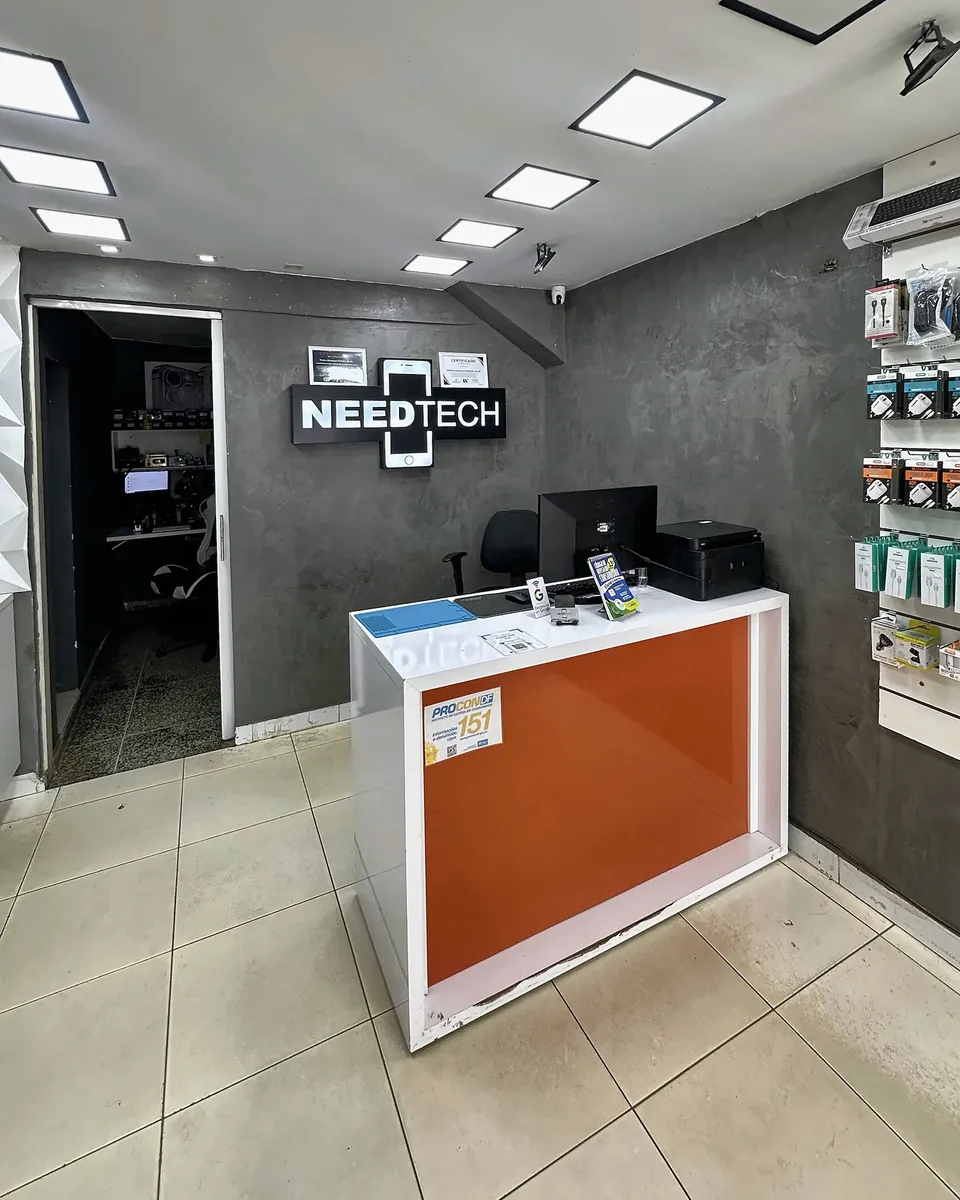 Balcão de atendimento da NeedTech com identificação da marca na parede